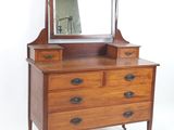 une commode en bois surmontée d'un miroir
