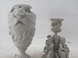 two statues of a man with a beard and a woman with a vase