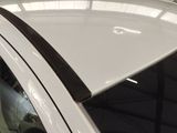 a close up of a white car with a black stripe on it