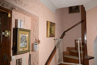 une photo d'un escalier dans une maison avec des tableaux accrochés au mur