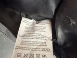 the label on the back of a black jacket is attached to the back of a black jacket