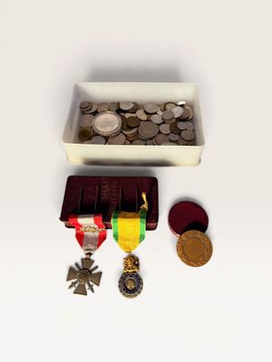 a small box of coins and a medal on a table