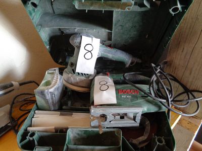 une mallette verte contenant des outils, posée sur une table