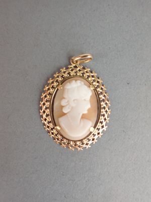 un gros plan d'un pendentif plaqué or représentant une femme
