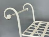 a white metal chair with a white seat and back