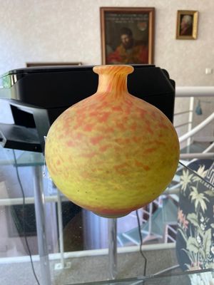 a yellow vase sitting on a glass table in a living room