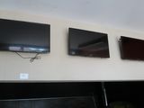 trois téléviseurs fixés au mur au-dessus d'une cheminée