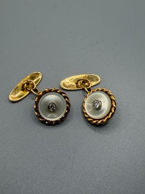 un gros plan sur une paire de boutons dorés et blancs