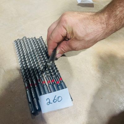 a man that is holding a bunch of drill bits in his hand