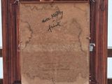 an old picture frame with writing on it sitting on a table