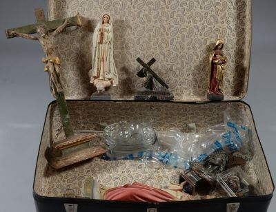 une valise remplie de statuettes religieuses et d'un crucifix
