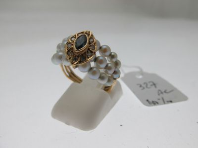 une photo en gros plan d'une bague ornée de perles et d'une étiquette