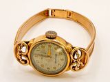 an image of a gold wrist watch with a chain around it