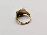 a gold ring on a white surface