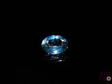 a close up of a blue diamond on a black surface