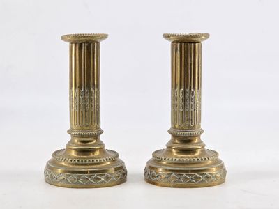 pair of antique brass candlesticks on a white background