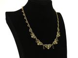 a black mannequin with a gold necklace on it
