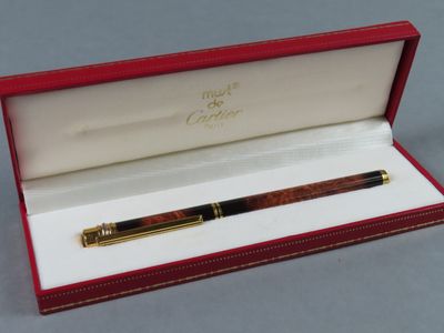 un gros plan d'un stylo dans une boîte rouge posée sur une table