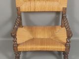 une vieille chaise en bois avec une assise tressée sur fond gris