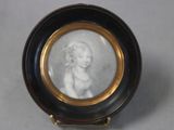 a miniature picture of a woman in a black and gold frame