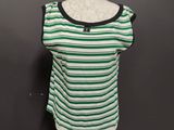 a green and white striped top on a mannequin stand