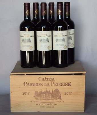 four bottles of wine are in a wooden box on a table