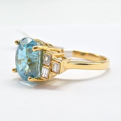 une photo d'une bague en topaze bleue sertie de deux diamants