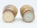 pair of vases sitting on top of each other on a white surface