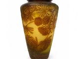 un vase marron orné de pommes de pin sur fond blanc