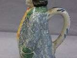 a blue and green pitcher with a bird on it