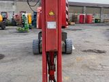 an image of a red hydraulic jack in a parking lot