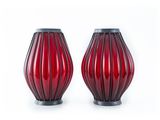pair of red glass vases with black bases on a white background