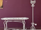 une table en fer forgé blanc et une lampe sur le trottoir
