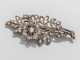 un gros plan d'une broche en argent ornée de perles sur un fond blanc
