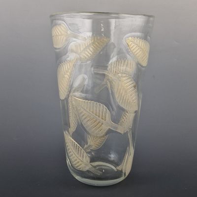 un vase en verre orné d'un motif de feuilles