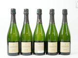 six bouteilles de champagne alignées sur une surface blanche