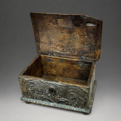 une vieille boîte en bois posée sur une surface grise