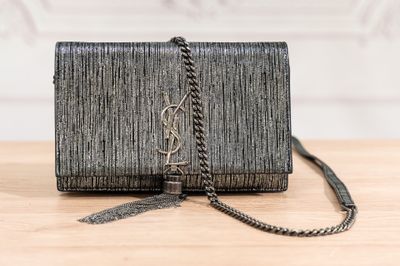 a black clutch bag sitting on top of a wooden table