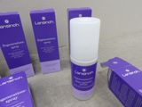 some purple boxes are sitting on a table next to a bottle of lotion and a box of lotion