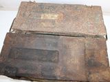 two old rusty metal boxes sitting on a white surface