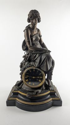 statue en bronze représentant une femme assise au sommet d'une horloge