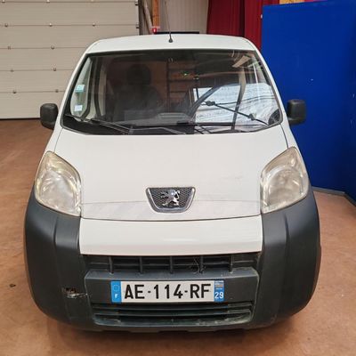 une petite voiture blanche garée dans un garage