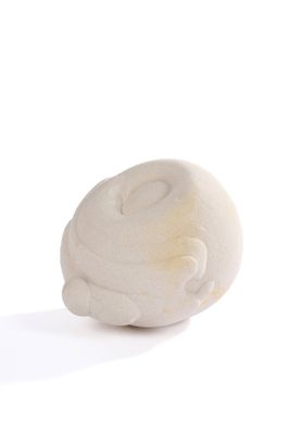 une sculpture blanche représentant un chat posée sur une surface blanche