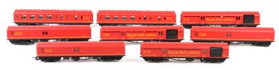 several red train cars are lined up on a white surface