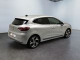 the rear end of a silver car in a white room