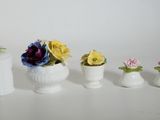 four small vases with flowers in them on a table