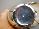 a person that is holding a silver watch in their hand
