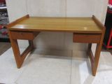 a small wooden desk with a drawer on it