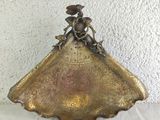 antique brass scallop with a lady on top of it on a table