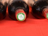 four bottles of wine are lined up on a red table